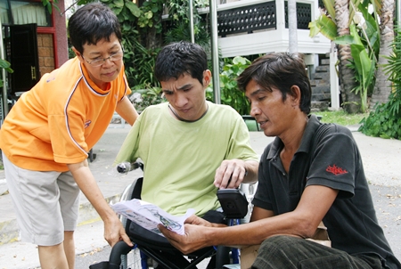 Den, center, receives the instructions for his new wheelchair.